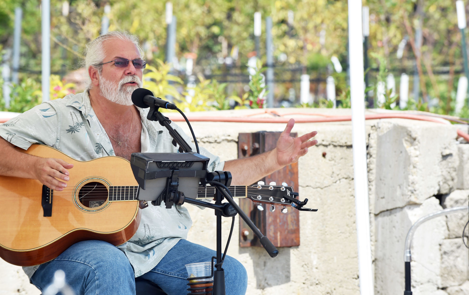 Rick Venn of The Rotten Bros. tells a story between songs at Sunday's farmers market at Milaeger's